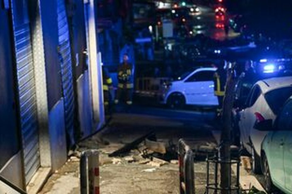 La serranda divelta e i detriti davanti alla concessionaria Gold Car in via dei Platani, a Centocelle, dopo l'esplosione dell'ordigno