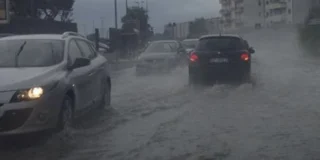 Un treno regionale con il mare in burrasca sullo sfondo: in Calabria allerta arancione, treni sospesi tra Lamezia e Rosarno e scuole chiuse